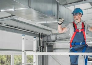 H V A C Technician performing maintenance on air ducts